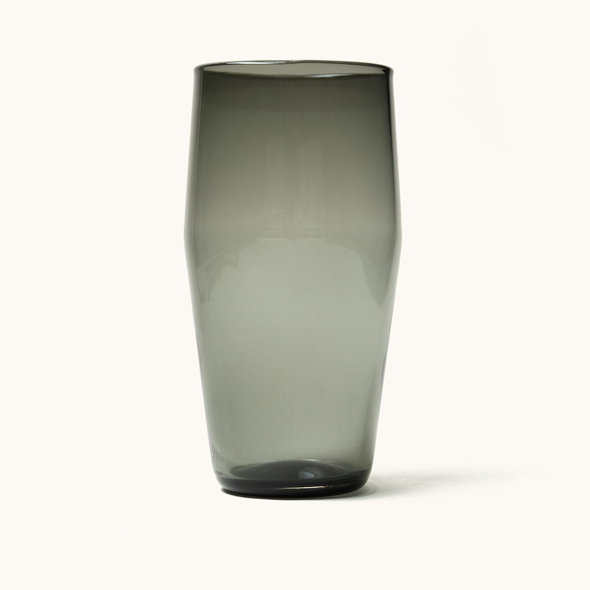 Smoky grey Standard Pint Glass with a tapered shape and dark glass bottom, isolated on white.