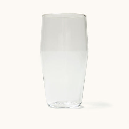 Clear standard pint glass, empty, with a subtle textured pattern on the base.