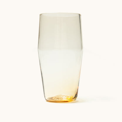 Amber-tinted standard pint glass with a tapered shape and textured base.