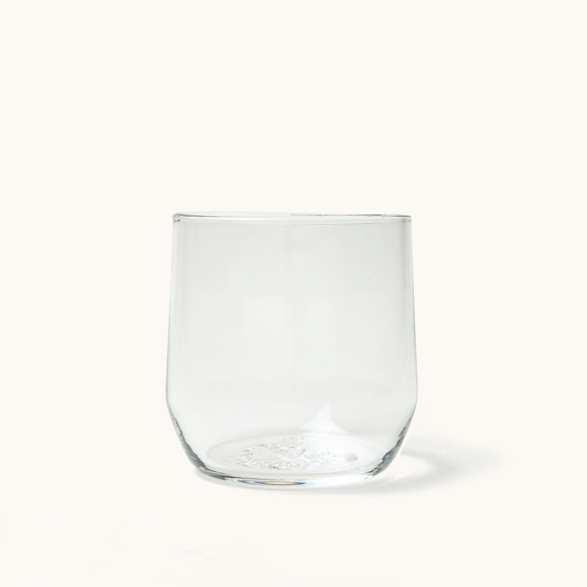 Clear, stemless cocktail glass with a gently curved silhouette, pictured on a white background.