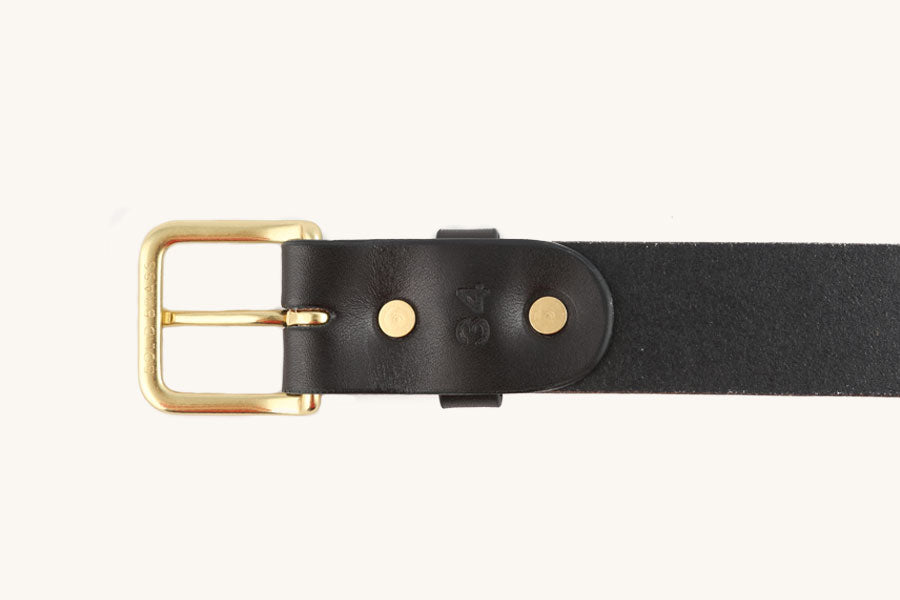 Black leather belt with a solid brass buckle and two gold rivets, showing an embossed '34'.
