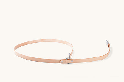 Natural leather convertible canine lead with silver-toned clasps and rivets, laid on a light background.