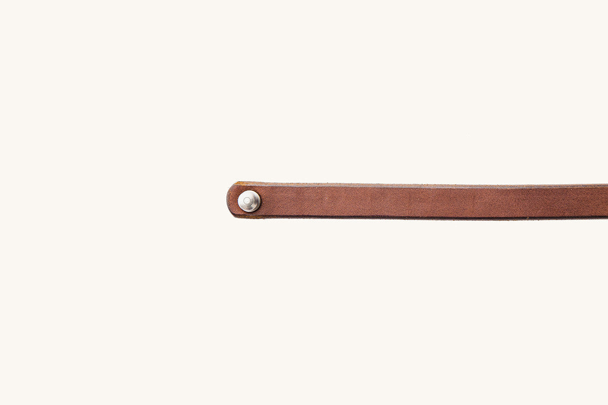 Cognac leather double wrap wristband with a silver rivet at one end.